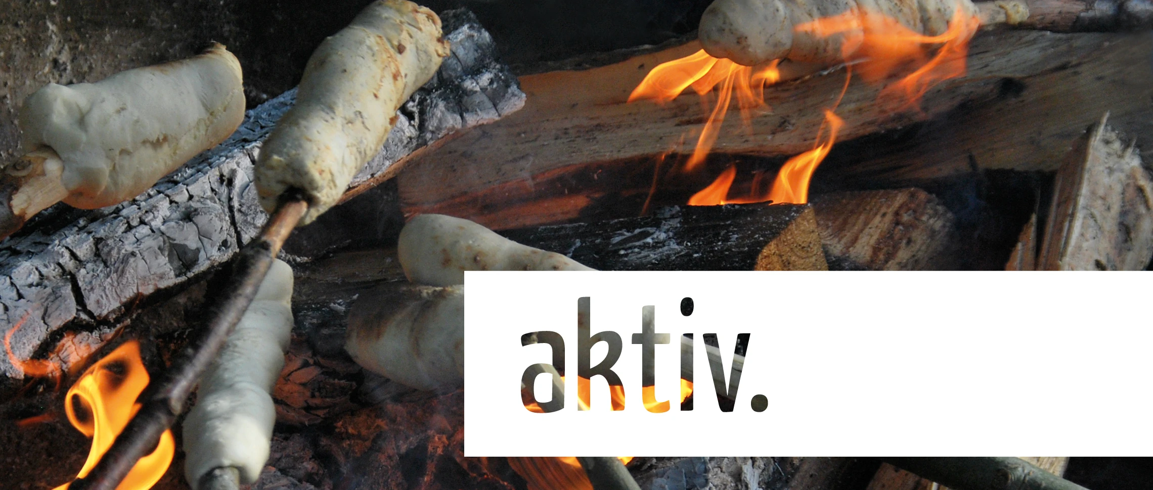 Stockbrot über einem Lagerfeuer, Schriftzug „aktiv.“